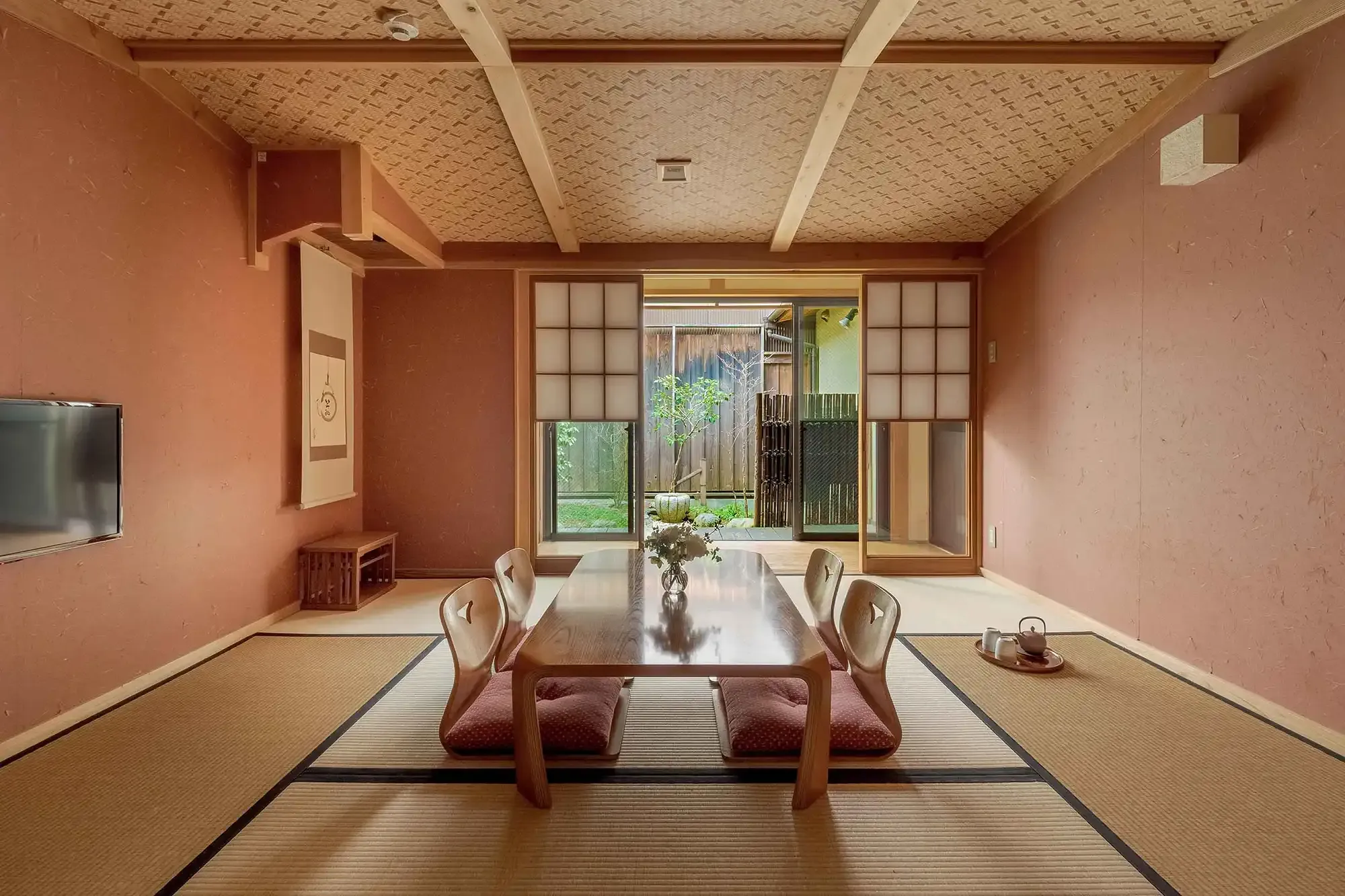 A private townhouse holiday home in Kyoto — tatami living room open to its tsuboniwa garden